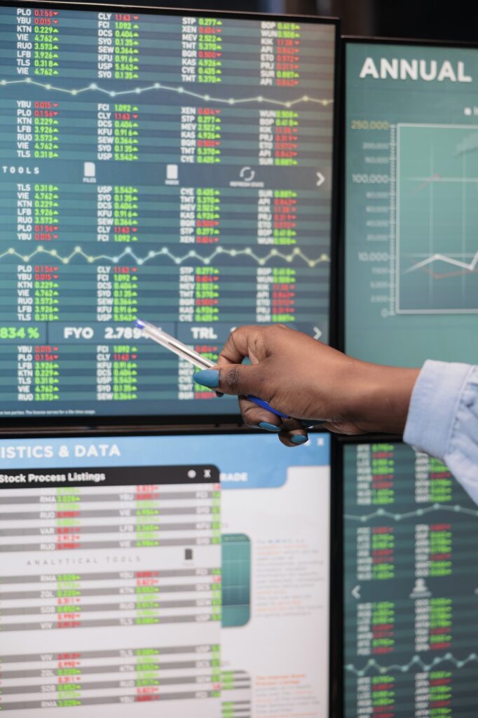 close up shot of forex stock market trader woman pointing at screen showing real time trading data